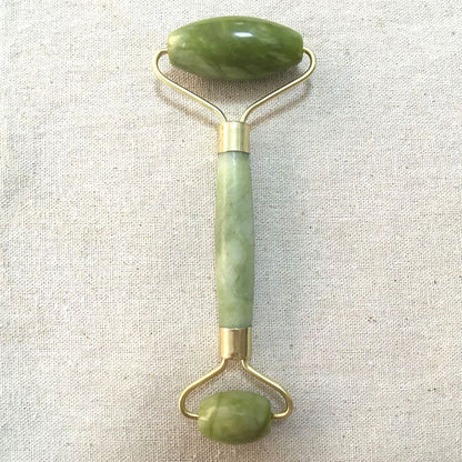 Woman using jade facial roller during skincare routine