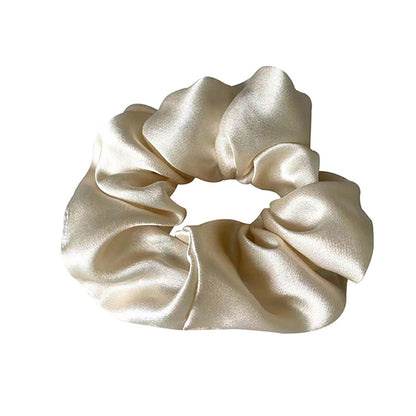 Smooth finish hair scrunchie in soft satin texture worn in low bun hairstyle luxury styling