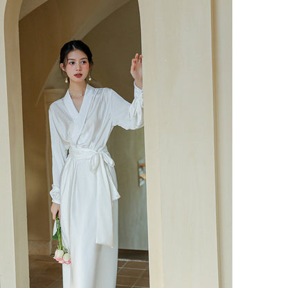 Woman in a white robe standing in a doorway